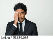 An adult young Asian man suffers from a sudden headache on a white background. Стоковое AI-изображение, AI-художник Ярославский Максим / Фотобанк Лори