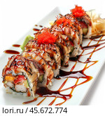 Delicious uramaki sushi rolls with eel, tobiko and sauce decorating a white plate. Стоковое AI-изображение, AI-художник Иван Рябоконь / Фотобанк Лори