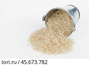 Rice grains spilling out of bucket. Стоковое фото, фотограф Александр Собко / Фотобанк Лори