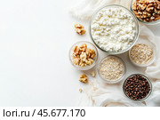 Cottage cheese or curd cheese. Cottage cheese bowl with Fresh Fruit, Berries, Oatmeal, Nuts. Various fermented dairy product rich in protein, healthy fats, calcium. Quark, tvorog and useful toppings. Стоковое AI-изображение, AI-художник Марина Демидюк / Фотобанк Лори