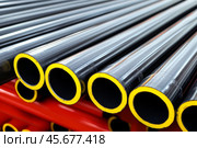 Long black yellow pipes. Large galvanized pipe stacked in industrial warehouse. Construction materials for infrastructure work. Metalwork. PVC pipes for sewerage pipeline, plumbing in the storage. Стоковое AI-изображение, AI-художник Марина Демидюк / Фотобанк Лори
