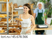 Portrait of a young girl with a bocadillo in her hands in the interior of private bakery. Стоковое фото, фотограф Яков Филимонов / Фотобанк Лори