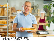 Portrait of male customer holding bocadillo in bakery interior. Стоковое фото, фотограф Яков Филимонов / Фотобанк Лори