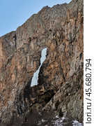 Frozen waterfall on high sheer cliff rock. Collapsed Icefall in mountains. Стоковое фото, фотограф Екатерина Якименко / Фотобанк Лори