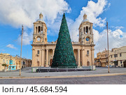 Christmas Tree in Front of Twin Bell Towers of Historic Christ the King Church in Malta. Стоковое фото, фотограф Kira_Yan / Фотобанк Лори