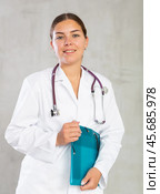 Happy female doctor standing with file in hands. Стоковое фото, фотограф Яков Филимонов / Фотобанк Лори