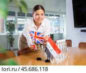 Young lady sets miniatures flags of Iraq and Great Britain for international negotiations. Стоковое фото, фотограф Яков Филимонов / Фотобанк Лори
