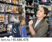 Young woman chooses keychain at souvenir market. Стоковое фото, фотограф Яков Филимонов / Фотобанк Лори