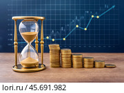 Hourglass with columns of coins on growth chart background. Стоковое AI-изображение, AI-художник Сергей Комаров / Фотобанк Лори