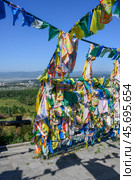 ULAN-UDE,  RUSSIA - AUGUST 11, 2024. Fluttering pieces of cloth with sacred texts - 'Him Morin' - symbols of Buddhism. Редакционное фото, фотограф Сергей Фролов / Фотобанк Лори