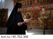 Монашка в церкви читает молитву (2024 год). Редакционное фото, фотограф Дмитрий Киселёв / Фотобанк Лори