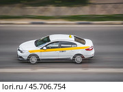 Motion city street scene with white taxi vehicle. Fast moving white taxi car on Moscow streets (2020 год). Редакционное фото, фотограф Константин Григорьев / Фотобанк Лори