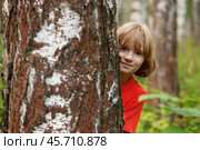 Boy peeking out from behind a tree trunk. Стоковое фото, фотограф Дмитрий Киселёв / Фотобанк Лори