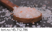 Himalayan pink salt in a wooden is used to flavor food. Due mainly to marketing costs, pink Himalayan salt is up to twenty times more expensive than table or sea salt. Стоковое видео, видеограф Андрей Армягов / Фотобанк Лори