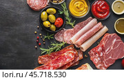Variety of sausage products. Meat products, Pork, Ham, bacon. Various kinds of sausages on a rustic wooden table among a black wall. Smoked meats on a wood cutting board showcasing deli promotions. Стоковое AI-видео, аниматор Марина Демидюк / Фотобанк Лори
