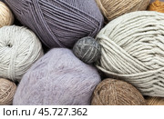 Textile background from skeins and balls of natural wool yarn for hand knitting in gray and beige shades. Yarn texture. Knitting and crocheting as a hobby. DIY concept. Flat lay, close-up, top view. Стоковое фото, фотограф Виктория Катьянова / Фотобанк Лори