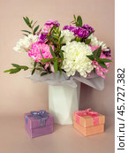 Greeting card for happy birthday, women's day on March 8, valentine's day, mother's day or family holiday. Beautiful bouquet of delicate fresh flowers and gift boxes. Festive romantic congratulation card. Стоковое фото, фотограф Виктория Катьянова / Фотобанк Лори