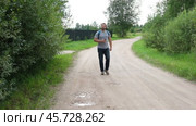 Exploring Nature a Hiker with backpack Strolling Through a Beautiful Field Beneath Vast Blue Sky. Tourist man traverses a scenic field, clear blue sky. Adventure and exploration concept. One person. Стоковое видео, видеограф Марина Демидюк / Фотобанк Лори