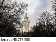 The main building of Lomonosov Moscow State University and cloudy autumn sky. Moscow State University MGU between the branches of trees. Стоковое фото, фотограф Константин Григорьев / Фотобанк Лори