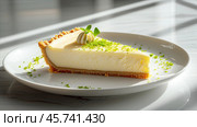 Slice of creamy key lime pie with a graham cracker crust, garnished with lime zest, whipped cream, and a mint leaf, served on a white plate in soft natural light. Стоковое AI-изображение, AI-художник Башкирова Анна / Фотобанк Лори