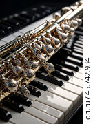 Close-up of gold flute on black white piano keys. Flute with piano, wind instrument for musical design of concert creativity. Music orchestra concert concept. Copy ad text space. Copy ad text space. Стоковое AI-изображение, AI-художник Aleksandr Golubev / Фотобанк Лори