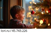 A Young Child Gazes out the Window, Mesmerized by the Sparkling Holiday Lights on a Cozy Winter Evening. Стоковое AI-изображение, AI-художник Sergey Grishin / Фотобанк Лори