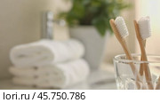 Toothbrushes in a cup on white countertop in bathroom background. Family toothbrushes in ceramic holder. Tooth brushes in mug. Oral care, wellness, dental hygiene, fresh breath. Toiletries Still Life. Стоковое AI-видео, аниматор Марина Демидюк / Фотобанк Лори