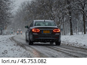 Car driving during winter snowstorm. Стоковое AI-изображение, AI-художник Александр Поташев / Фотобанк Лори