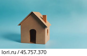 Paper house shape. Miniature Cardboard House model isolated on a light blue plain background. Home investment, savings. Real Estate Banner. Property Ownership Concept. Moving home idea. Rent, sell. Стоковое AI-видео, аниматор Марина Демидюк / Фотобанк Лори