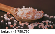 Himalayan pink salt in a wooden is used to flavor food. Due mainly to marketing costs, pink Himalayan salt is up to twenty times more expensive than table or sea salt. Стоковое видео, видеограф Андрей Армягов / Фотобанк Лори