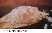 Himalayan pink salt in a wooden is used to flavor food. Due mainly to marketing costs, pink Himalayan salt is up to twenty times more expensive than table or sea salt. Стоковое видео, видеограф Андрей Армягов / Фотобанк Лори