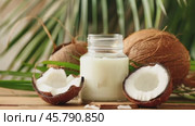 Solid purified coconut oil. Coconuts and palm branches background with coconut butter. Healthy organic food, vegetable oil. Стоковое AI-видео, аниматор Klimiankova Tatsiana / Фотобанк Лори
