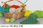 Needlework and knitting as a hobby. Video of wicker basket with balls and knitting needles and skeins of woolen yarn on the table. Still life with knit accessories. DIY concept, winter crafts. Стоковое видео, видеограф Виктория Катьянова / Фотобанк Лори