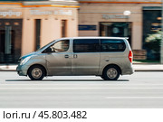 Gray passenger van Hyundai H1 in the city street. Side view of minivan in motion. Редакционное фото, фотограф Константин Григорьев / Фотобанк Лори