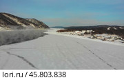 A snow-covered landscape with a river open in winter weather, near a remote village. Aerial view. Стоковое видео, видеограф Виктория Тельминова / Фотобанк Лори