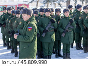 Maykop, Russia - January 13, 2024: a young soldier with a video camera in his hands in front of  young soldiers in green dress uniforms with Kalashnikov assault rifles. Редакционное фото, фотограф Андрей С / Фотобанк Лори
