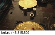 Gold Bit Coin BTC coins on the motherboard. Bitcoin is a worldwide cryptocurrency and digital payment system called the first decentralized digital currency. Стоковое видео, видеограф Андрей Армягов / Фотобанк Лори