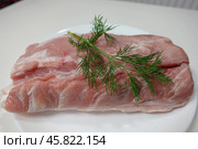 Сырой свиной карбонад на белой тарелке. Raw pork loin on a white plate. Стоковое фото, фотограф Юрий Пуликов / Фотобанк Лори