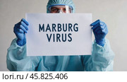 Doctor holding a banner with text Marburg Virus sign. Scientist in protective gear, gloves and medical mask. New epidemic illness. Outbreak of infectious disease spreading, worldwide pandemic. Стоковое AI-видео, аниматор Марина Демидюк / Фотобанк Лори