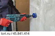 Construction worker drilling concrete wall with rotary hammer drill. Стоковое AI-видео, аниматор Юрий Поздников / Фотобанк Лори