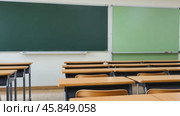 Modern classrooms interior with desks and green blackboard. Empty Classroom setup with school furniture and a chalkboard. No people. Nobody. Blurry view of class room with chairs and tables in campus. Стоковое AI-видео, аниматор Марина Демидюк / Фотобанк Лори