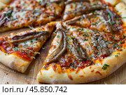 Pizza with mozzarella cheese and anchovies slices lying on wooden board. Стоковое AI-изображение, AI-художник Иван Рябоконь / Фотобанк Лори