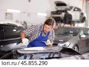 Experienced auto body technician puttying damaged car bumper. Стоковое фото, фотограф Яков Филимонов / Фотобанк Лори