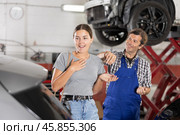 Happy female customer receiving car key from auto mechanic after repair. Стоковое фото, фотограф Яков Филимонов / Фотобанк Лори