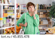 Customer with basket of groceries in hands suffers from headache, feels pain in temple area. Стоковое фото, фотограф Яков Филимонов / Фотобанк Лори