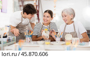 Group of cheerful people painting ceramic dishware in pottery class. Стоковое фото, фотограф Яков Филимонов / Фотобанк Лори