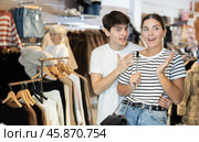 Young couple watching excitedly large stock of clothes in clothing store. Стоковое фото, фотограф Яков Филимонов / Фотобанк Лори