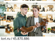 Guy male friend strongly recommends his young woman colleague to pay attention to model of boots. Стоковое фото, фотограф Яков Филимонов / Фотобанк Лори