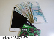 Смартфон, телефон, мобильник на фоне денег и банковских карт. Smartphone, phone, mobile on the background of money and bank cards. (2024 год). Редакционное фото, фотограф Юрий Пуликов / Фотобанк Лори