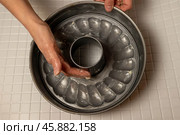 Baker greasing fluted tube pan with butter, getting ready to bake. Стоковое фото, фотограф Андрей Знаменский / Фотобанк Лори